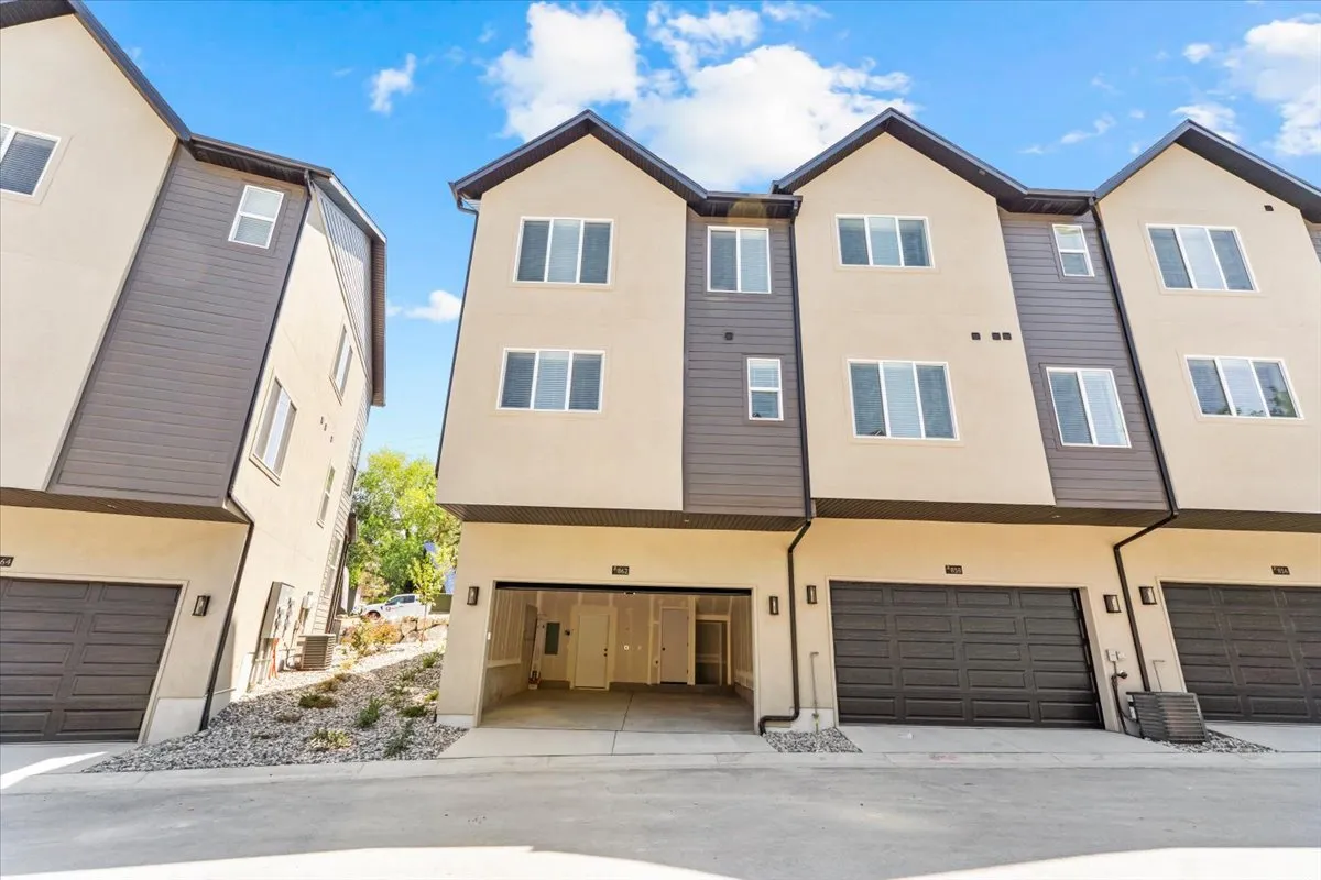 Multi-level townhome exterior featuring contemporary design, integrated garage, and textured siding