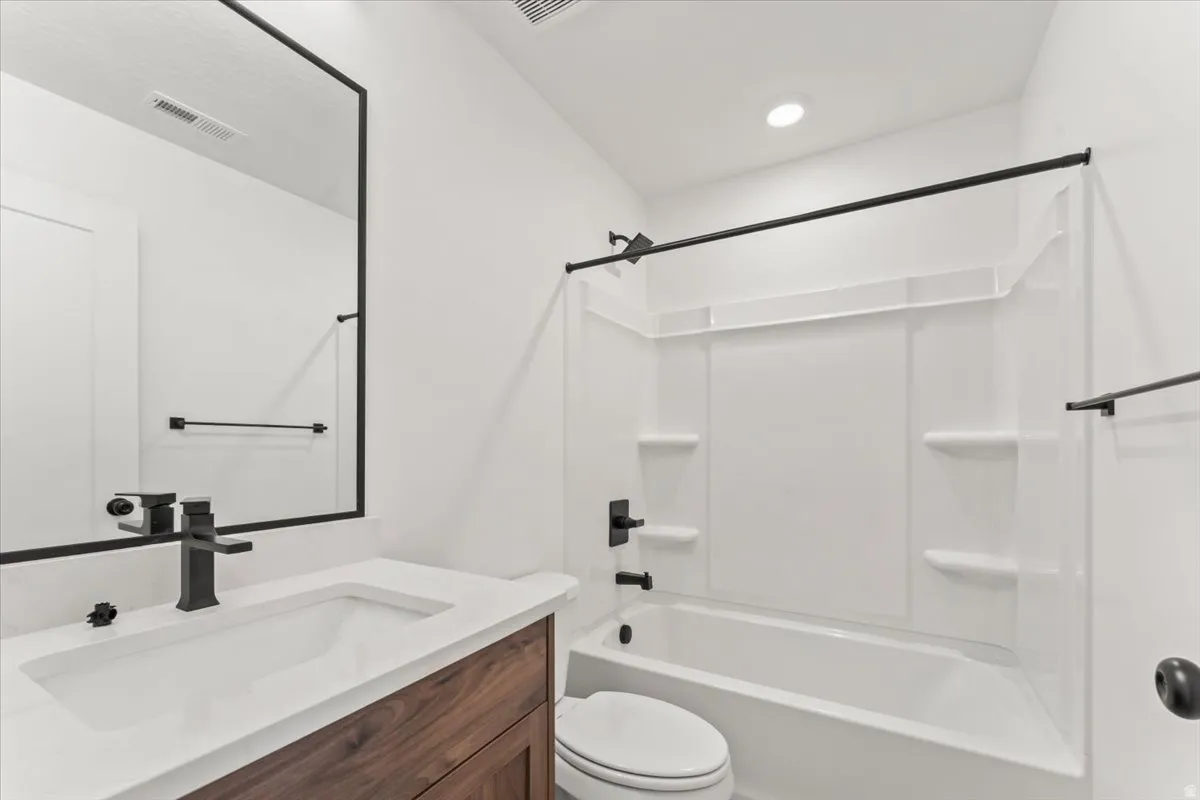 Bathroom featuring a single vanity with wood-finish cabinetry, a white countertop, and a rectangular undermount sink
