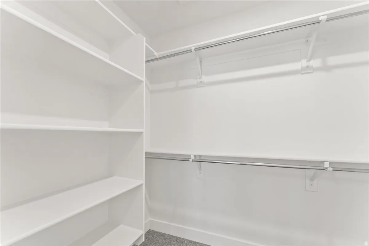 Built-in shelving, white walls, and dual clothing rods