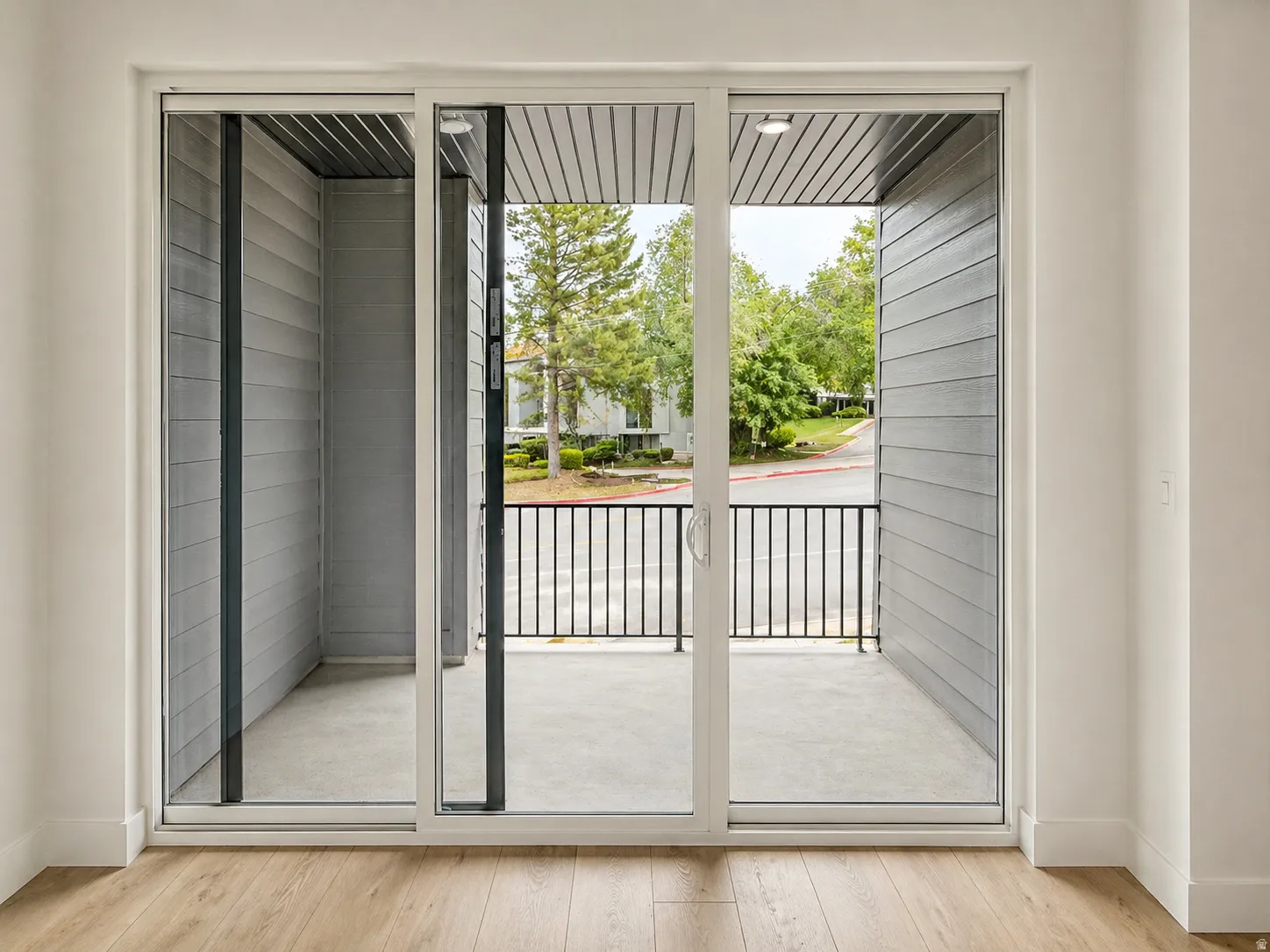 Patio with concrete flooring, black metal railing, and recessed lighting