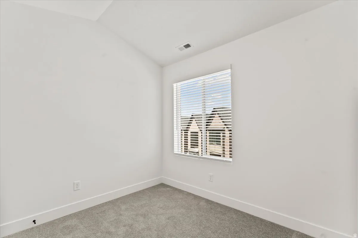 Neutral wall color, carpet flooring, window with blinds, and white trim