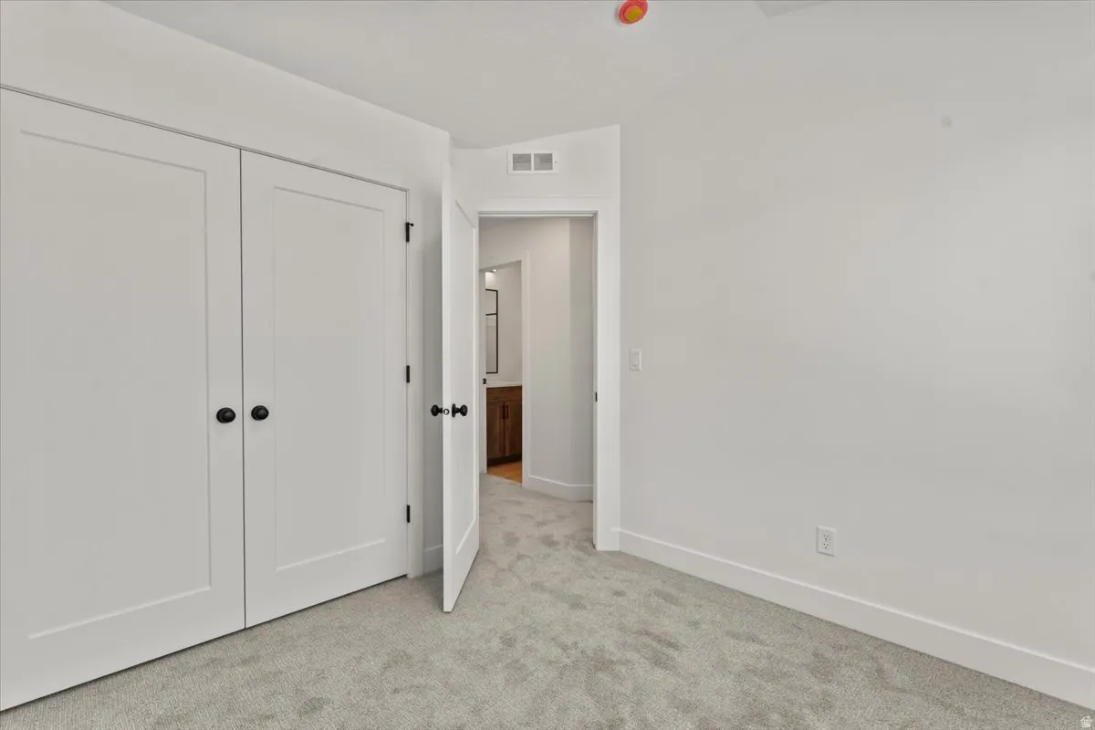 Wall-to-wall carpeting, white interior walls, and flat panel doors with dark hardware