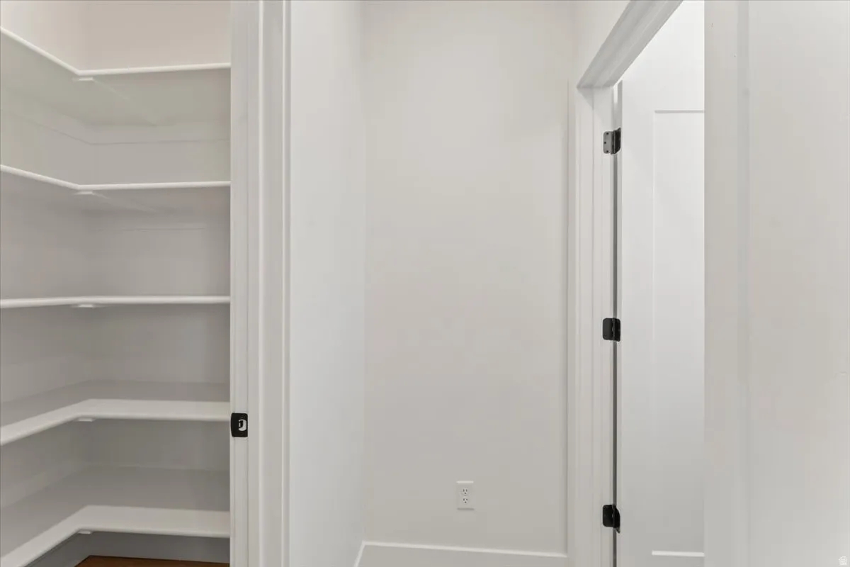 Corner shelving system, white interior walls, white trim, and dark hardware