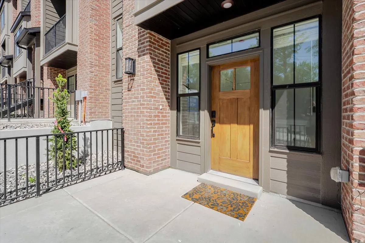 Entryway featuring a wood-panel door, transom window, sidelight windows, and brick exterior accents
