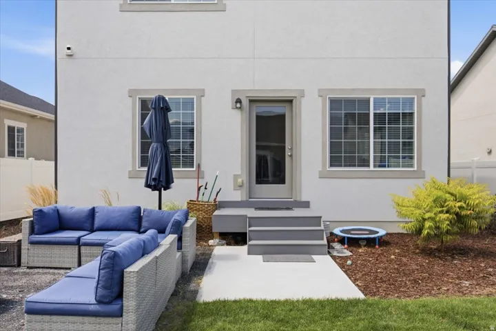 Exterior featuring a concrete patio, wood chip landscaping, and a glass-paneled entry door