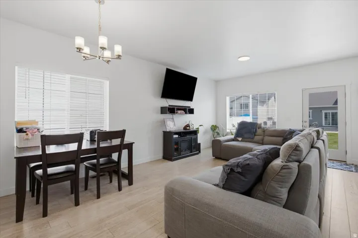 Open-concept living space with light wood-finish flooring, white walls, and recessed lighting