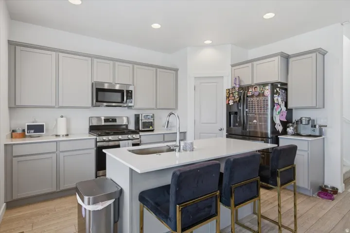 Kitchen featuring light gray cabinetry, white quartz countertops, and LVP wood-finish flooring