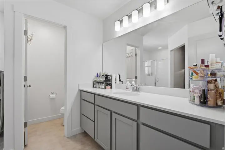 Maste bathroom featuring a dual vanity, light gray cabinetry, white countertop, and a large wall-mounted mirror