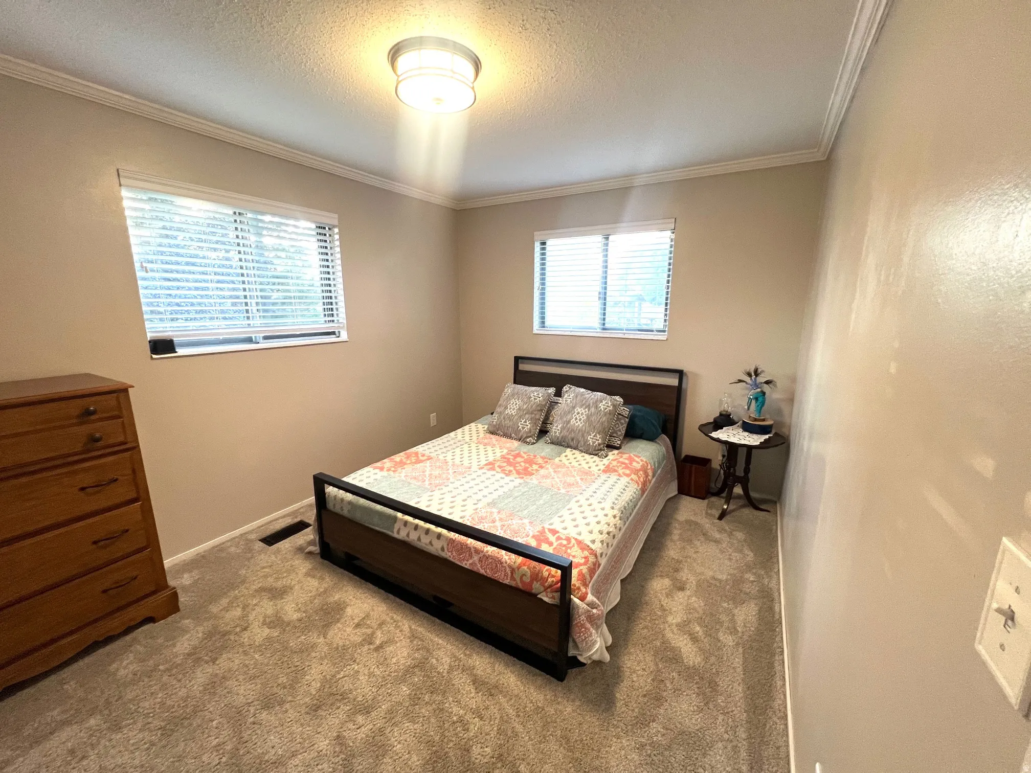Neutral-toned walls with crown molding, two windows with blinds, and recessed lighting