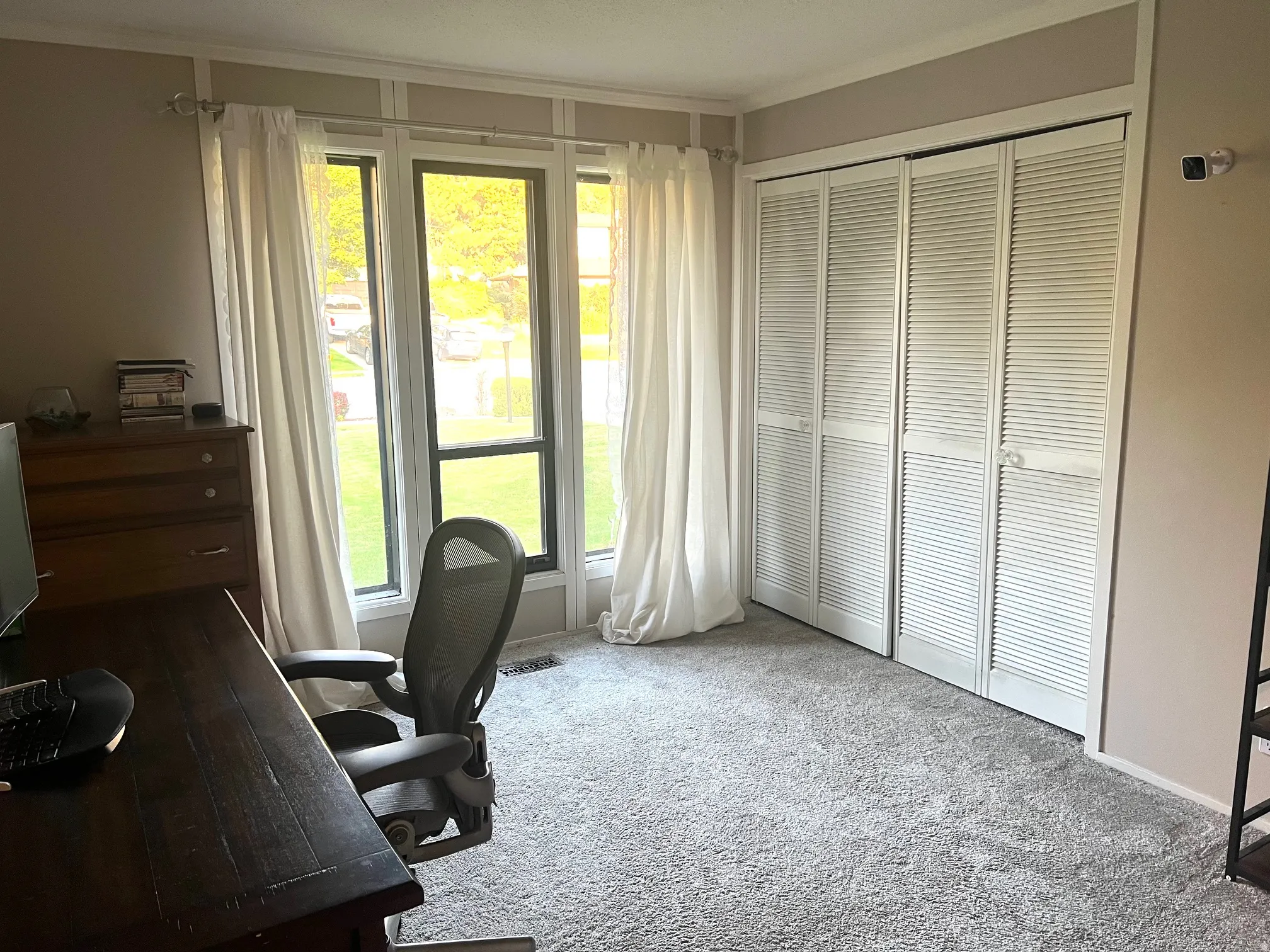 Window with multiple panes, paneled wall detail, and bi-fold louvered closet doors