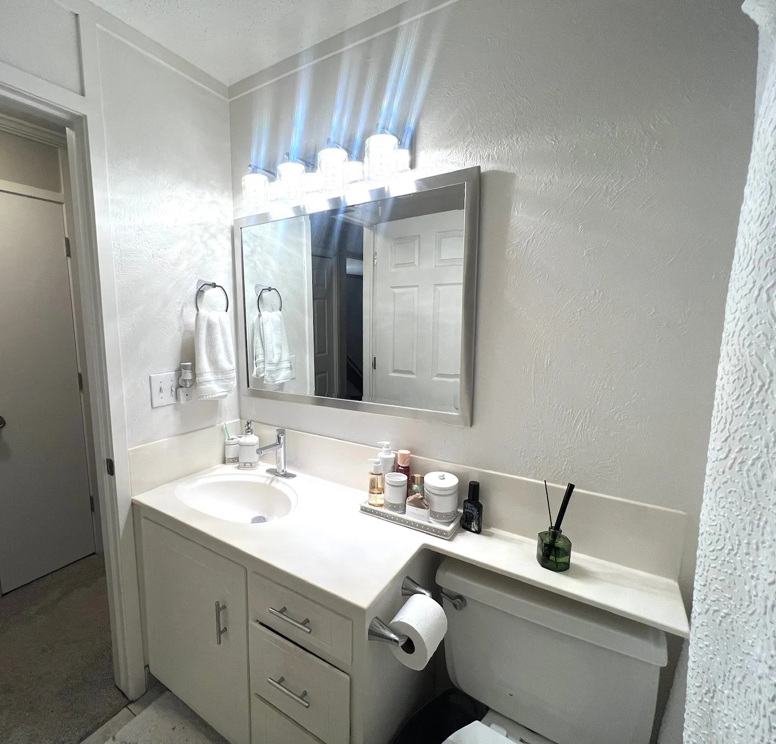Contemporary bathroom featuring a white vanity with dual drawers, white quartz countertop, and integrated sink