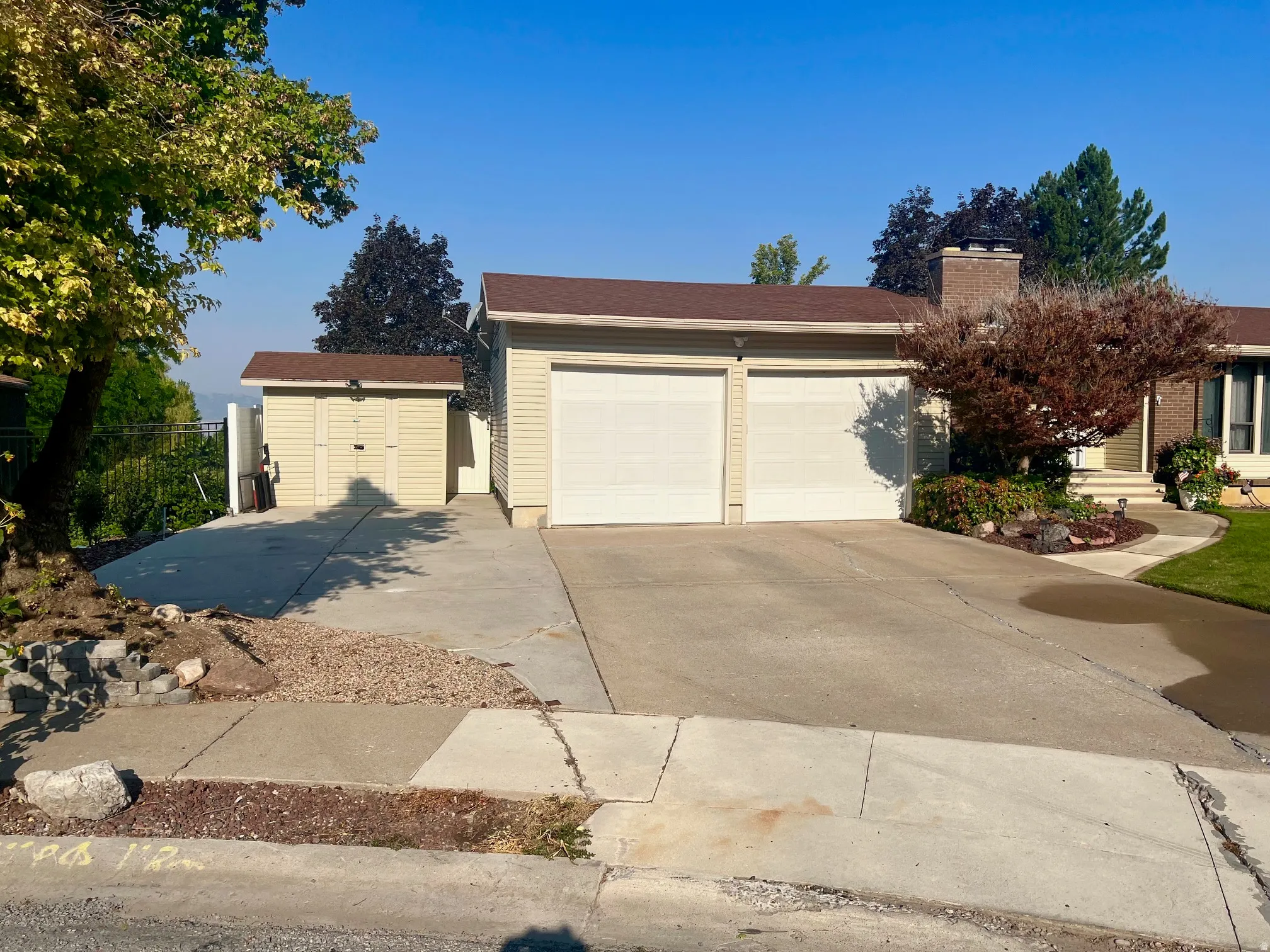 Expansive driveway with concrete surface providing ample parking for multiple vehicles
