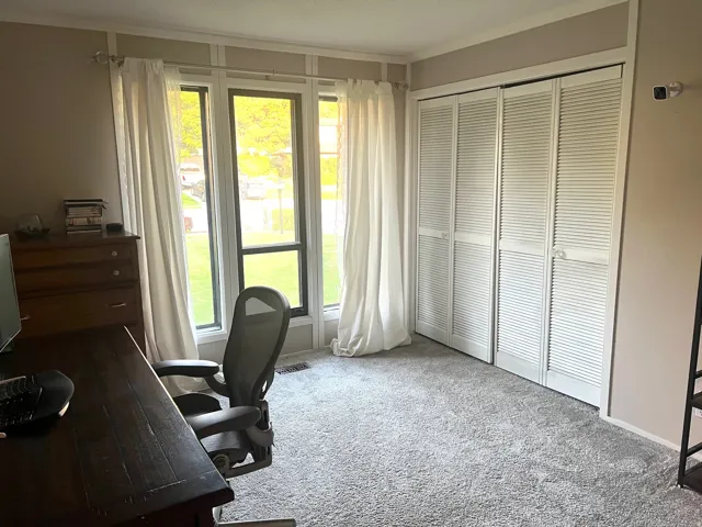 Window with multiple panes, paneled wall detail, and bi-fold louvered closet doors