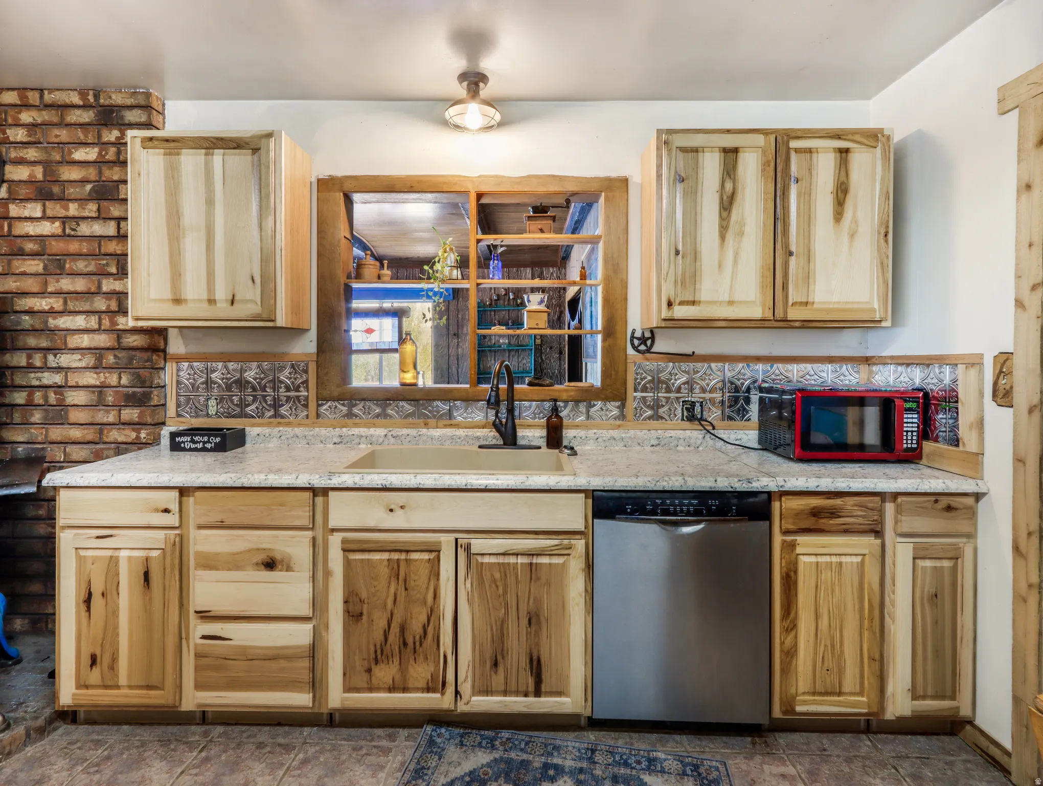 Wood-finish cabinetry paired with a solid surface countertop and undermount sink