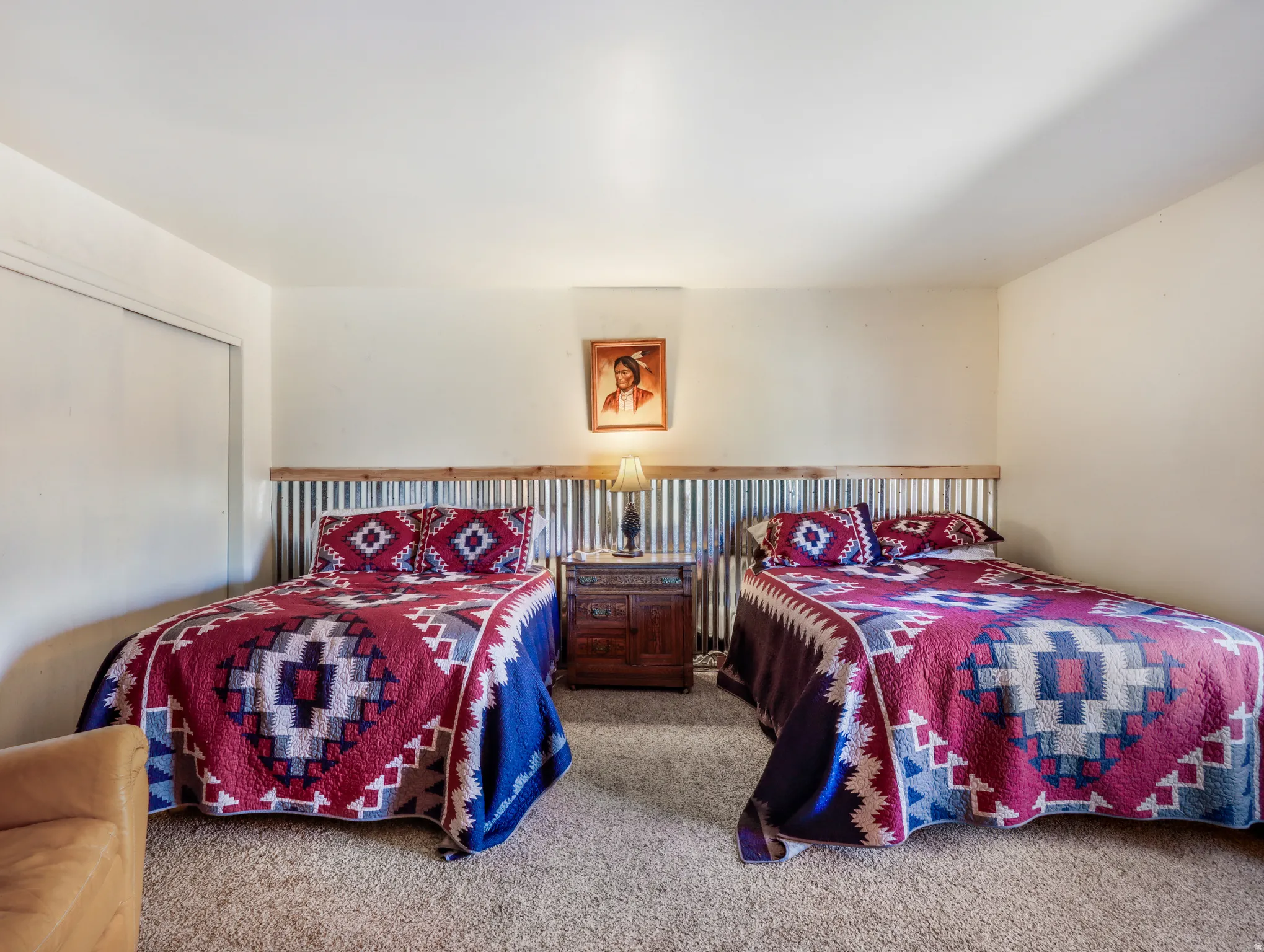 Corrugated metal wainscoting with wood trim, wall-to-wall carpeting, and sliding closet doors