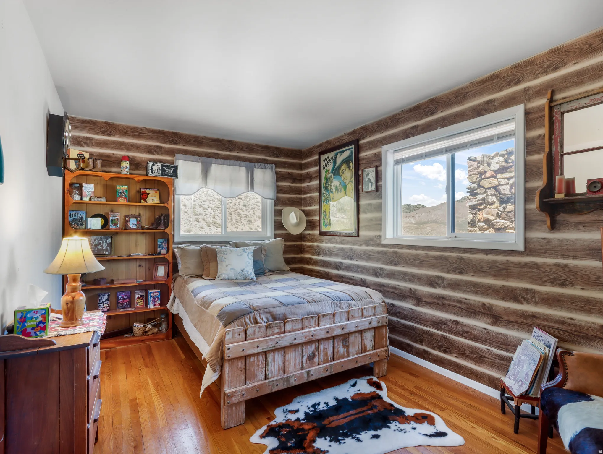 Wood-finish wall paneling, light wood-finish flooring, built-in shelving, and white-framed windows