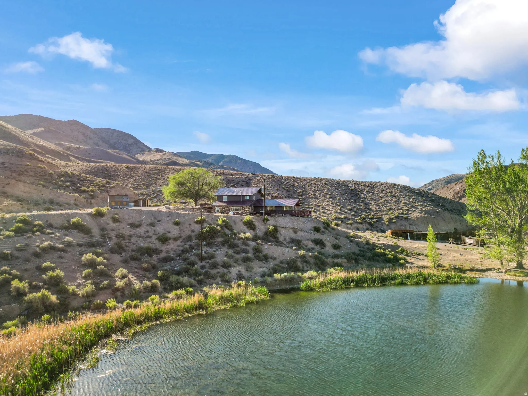 Waterfront property featuring a residential structure, a second auxiliary structure, and a large body of water