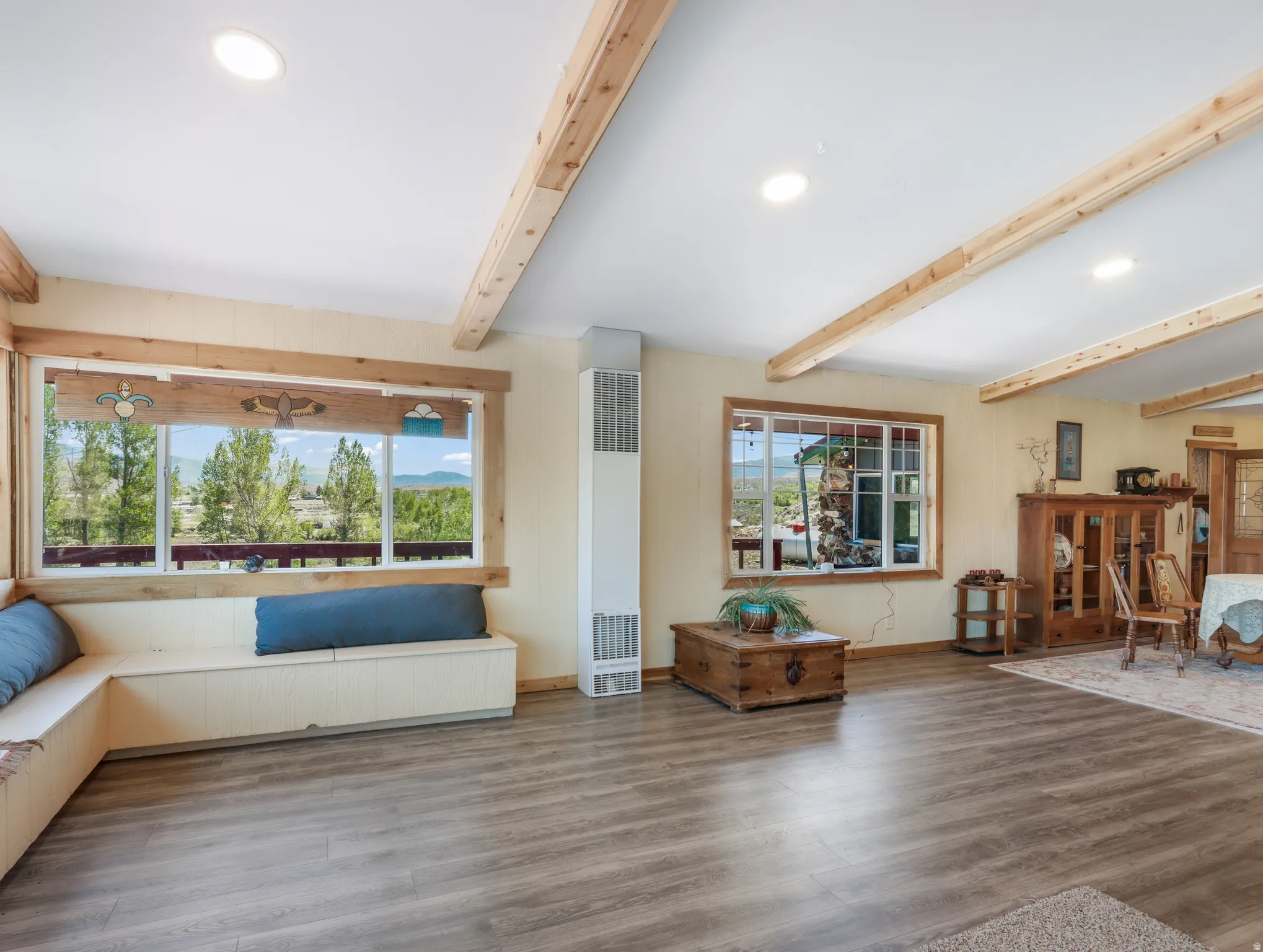 Wood-finish flooring throughout, complemented by exposed ceiling beams and recessed lighting