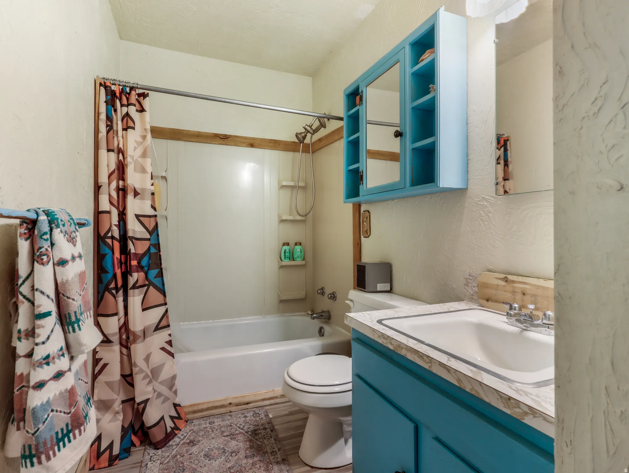 Full bathroom featuring a shower/tub combination, single vanity, and medicine cabinet with open shelving