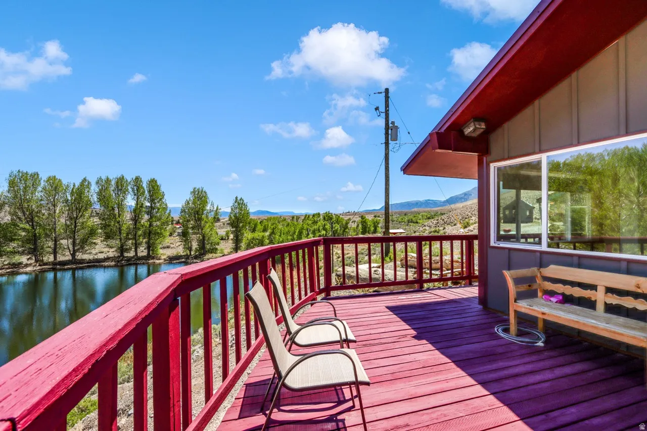Expansive outdoor deck with a red railing and matching wood-finish flooring