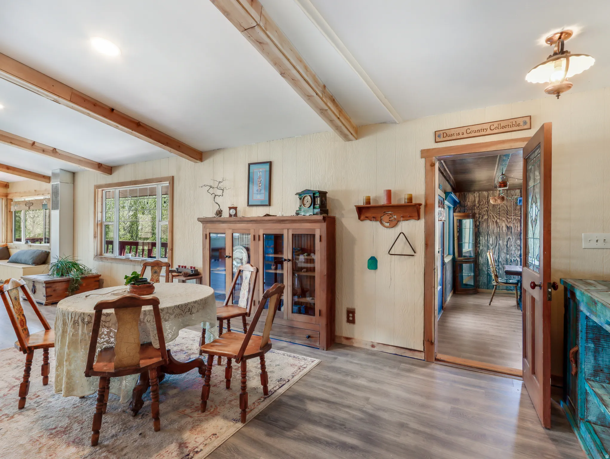 Wood-finish flooring, exposed ceiling beams, and a built-in window bench