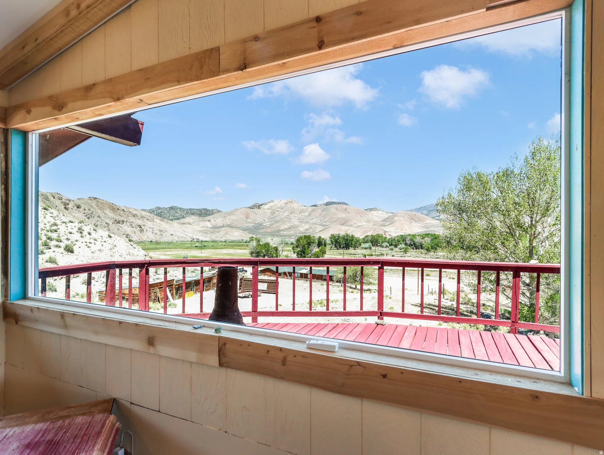 Expansive window providing broad outdoor scenery, wood-paneled walls, and wood trim details