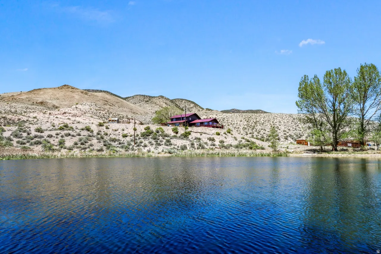 Waterfront property with natural landscaping, surrounded by arid hills