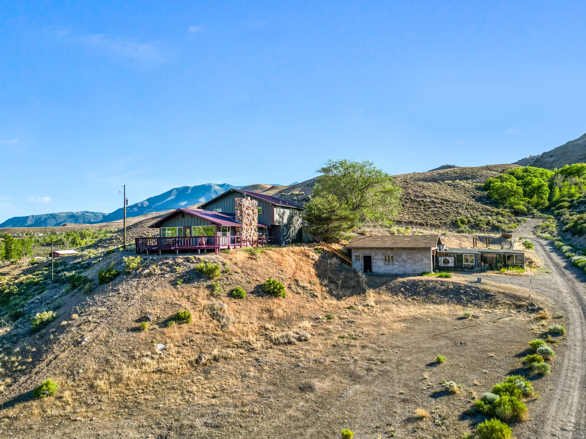 Stone exterior on the main residence, an expansive wrap-around deck, and a secondary structure