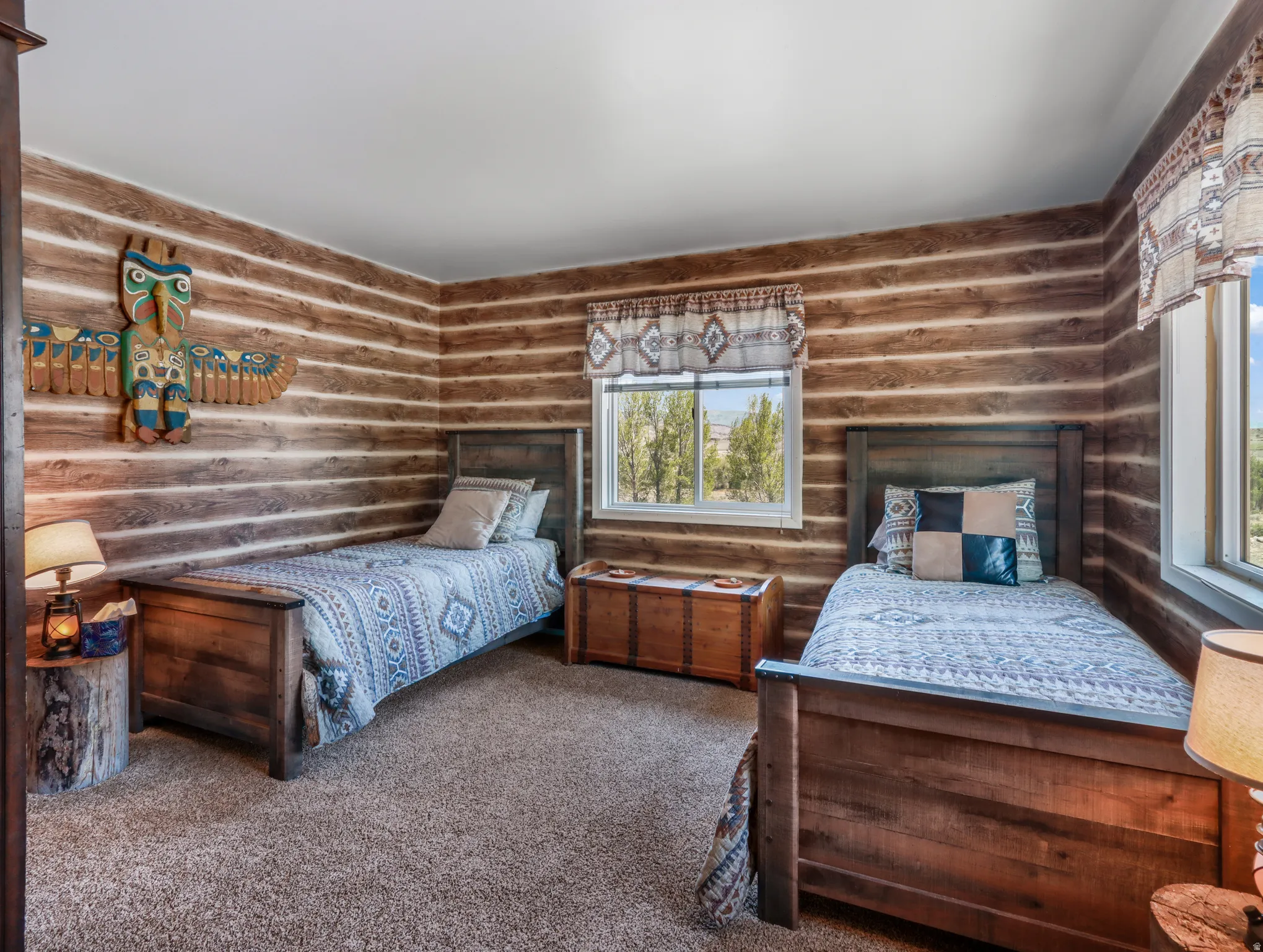Wood-paneled walls, carpeted flooring, and multiple windows with natural light