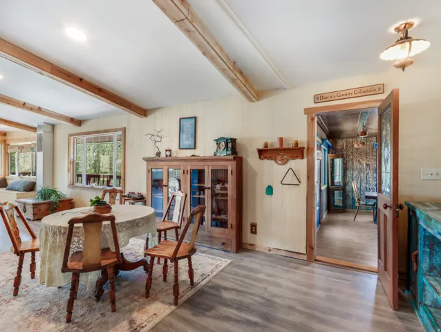 Wood-finish flooring, exposed ceiling beams, and a built-in window bench