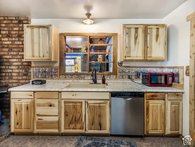 Wood-finish cabinetry paired with a solid surface countertop and undermount sink