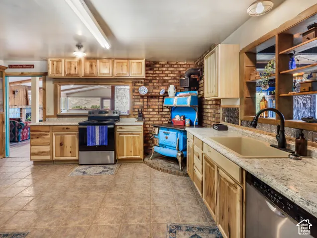 Kitchen featuring wood-finish cabinetry, tile flooring, brick accent wall, and a built-in range
