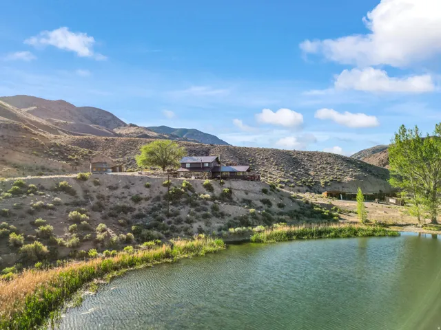 Waterfront property featuring a residential structure, a second auxiliary structure, and a large body of water