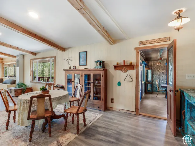 Wood-finish flooring, exposed ceiling beams, and a built-in window bench