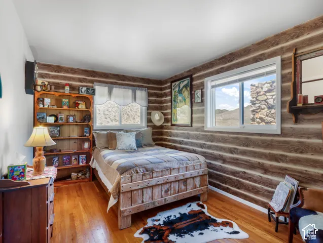 Wood-finish wall paneling, light wood-finish flooring, built-in shelving, and white-framed windows