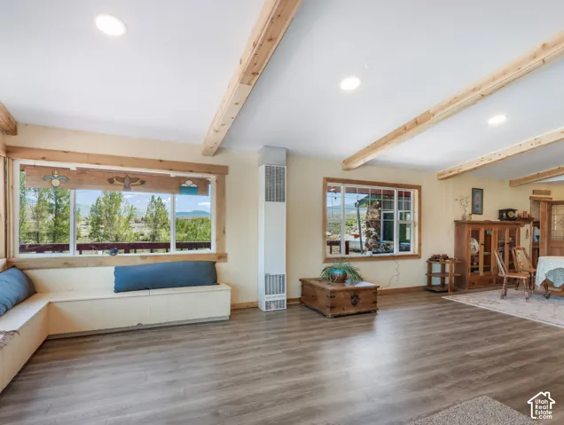 Wood-finish flooring throughout, complemented by exposed ceiling beams and recessed lighting
