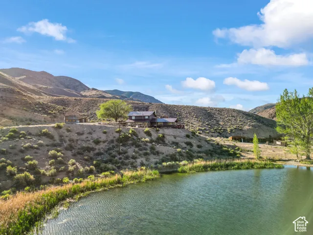 Waterfront property featuring a residential structure, a second auxiliary structure, and a large body of water