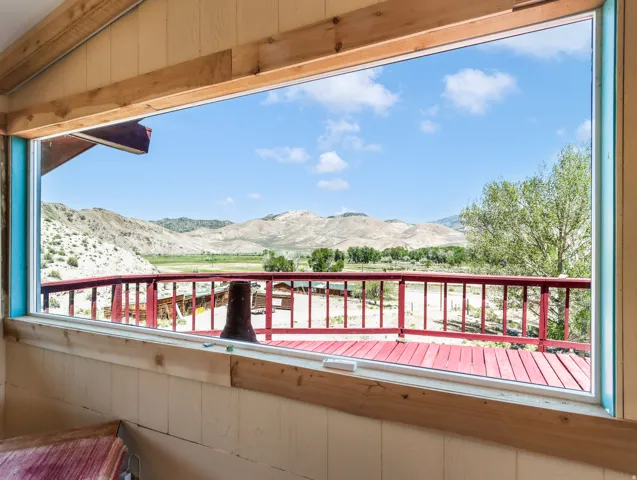 Expansive window providing broad outdoor scenery, wood-paneled walls, and wood trim details