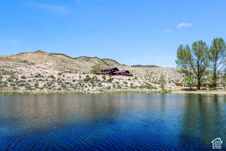 Waterfront property with natural landscaping, surrounded by arid hills