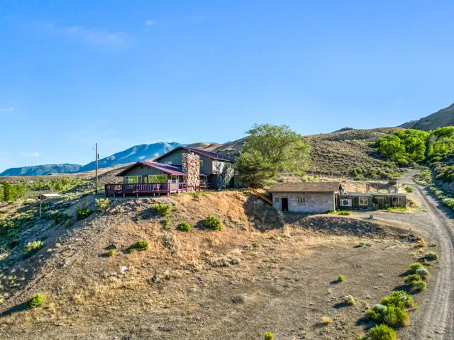 Stone exterior on the main residence, an expansive wrap-around deck, and a secondary structure