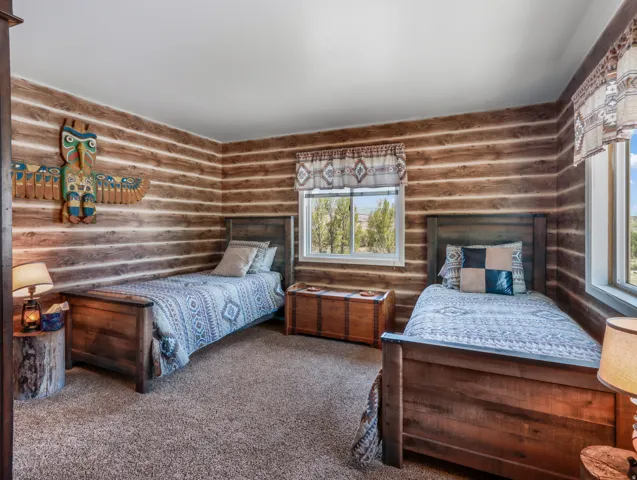 Wood-paneled walls, carpeted flooring, and multiple windows with natural light