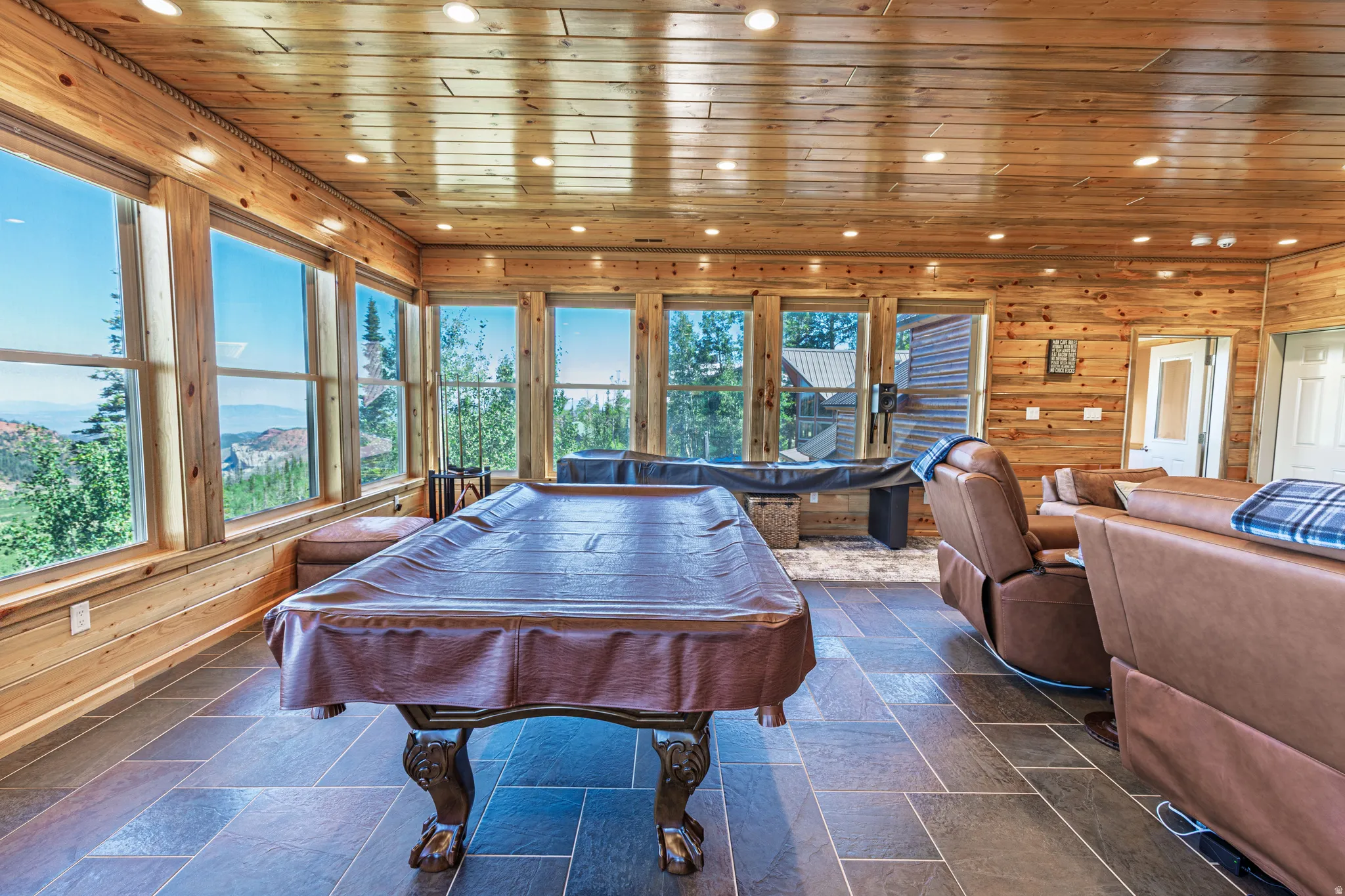 Wood paneling, recessed lighting, expansive windows, tile flooring, and a door with an opaque glass insert