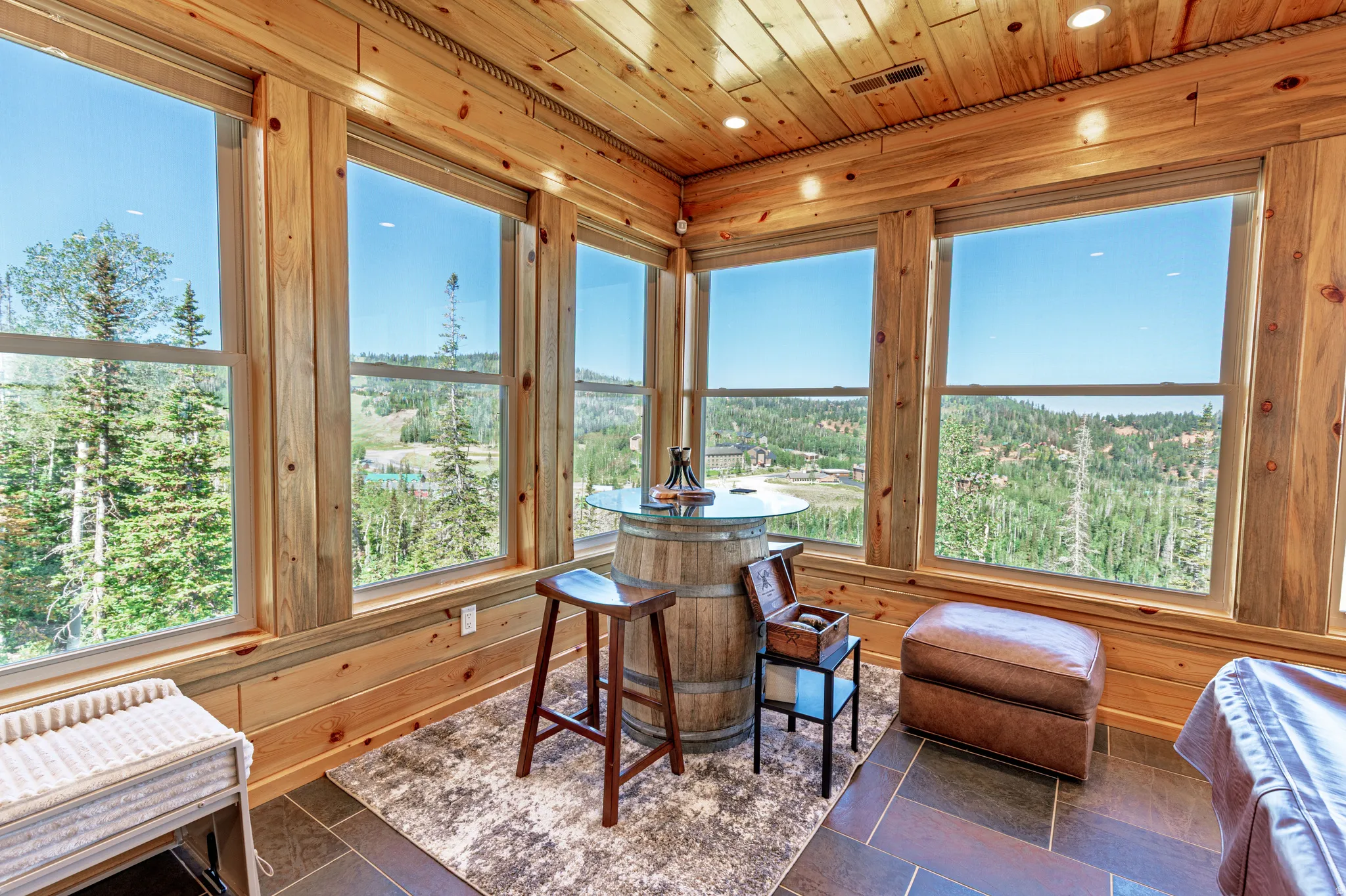 Expansive room with large windows, wood paneling, wood plank ceiling, recessed lighting, and tile flooring