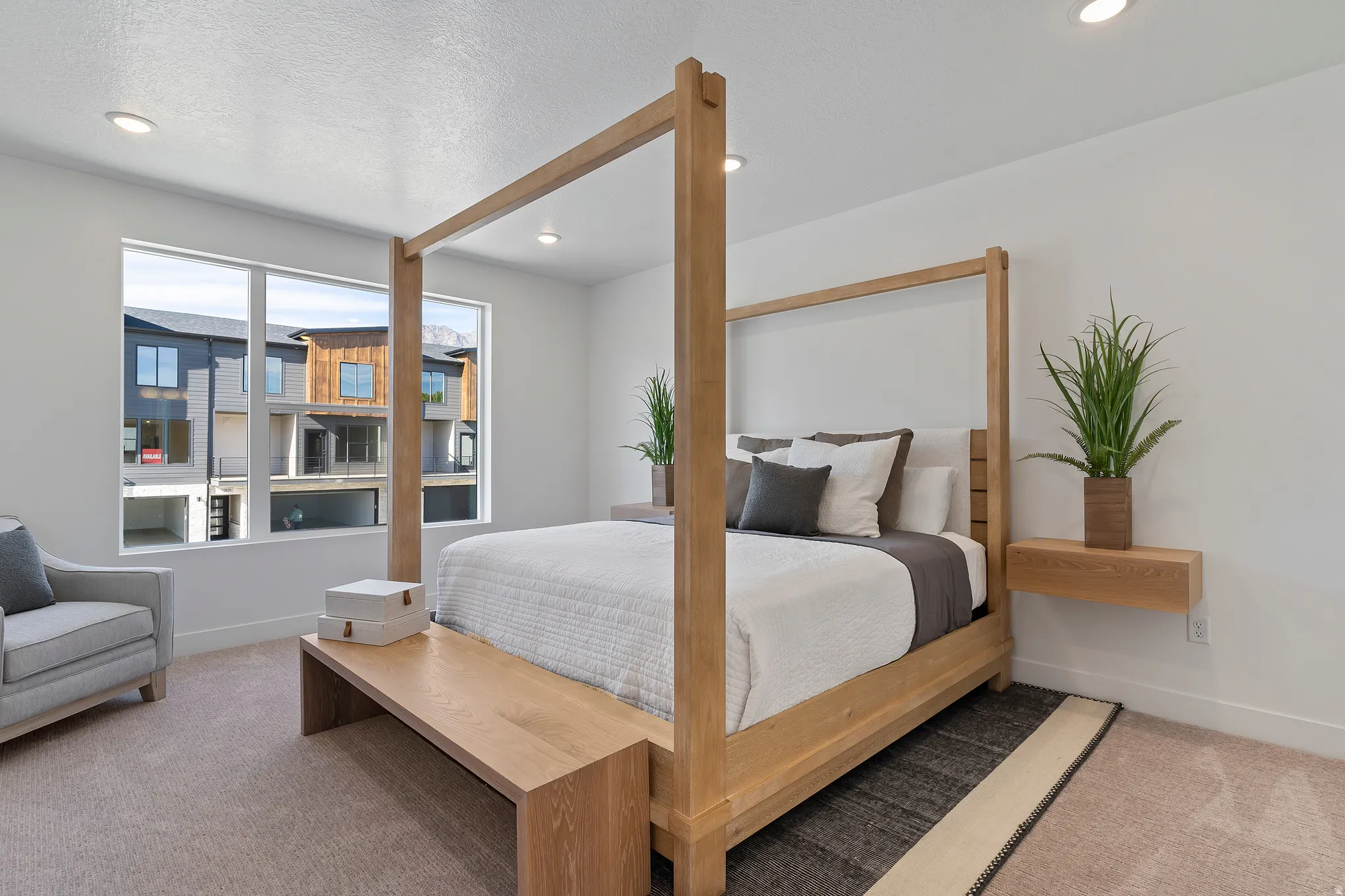 Recessed ceiling lighting, large windows, wall-mounted floating shelf, and carpeted flooring