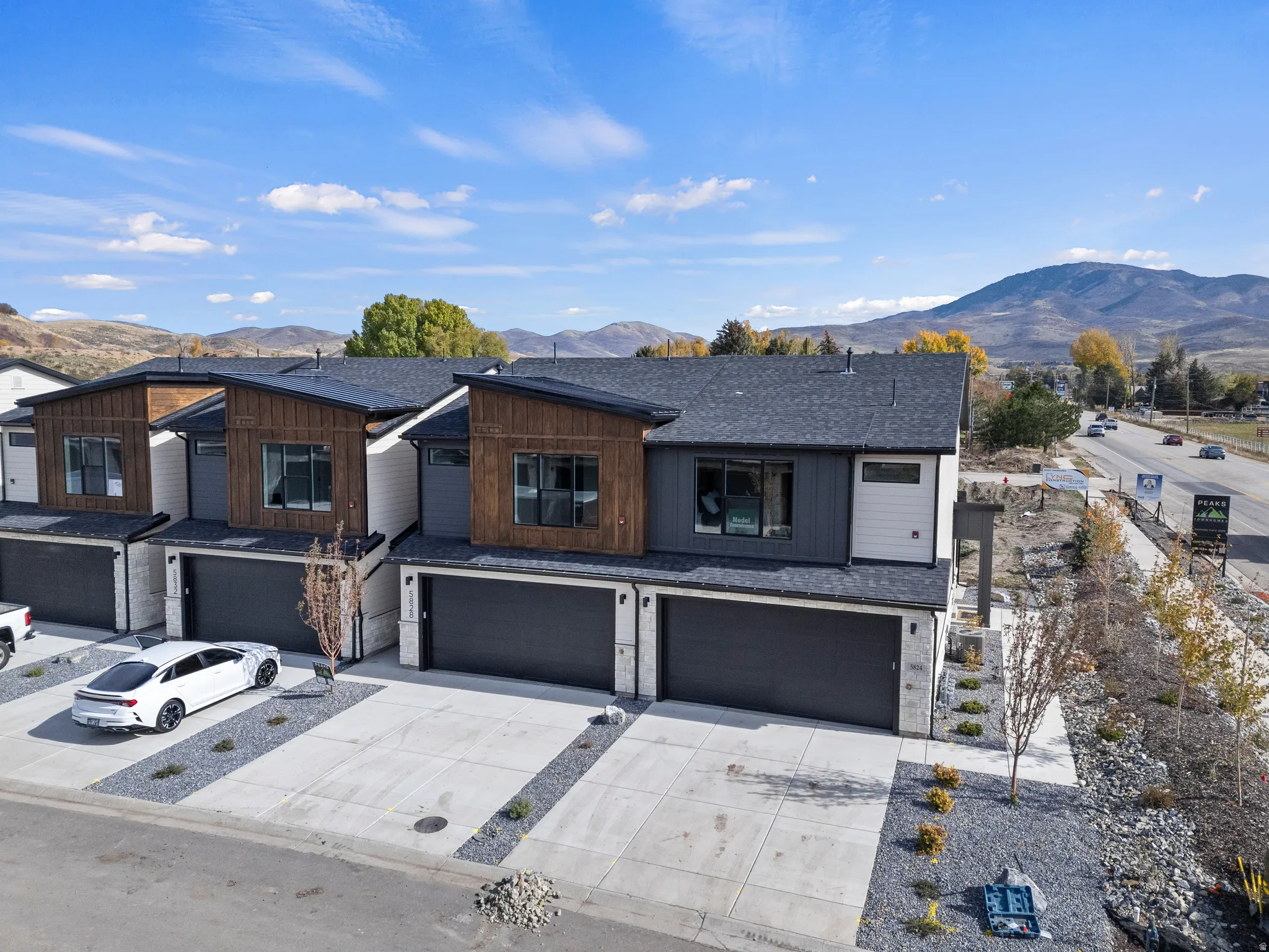 Modern facade featuring dark wood paneling, white siding, and stone accents
