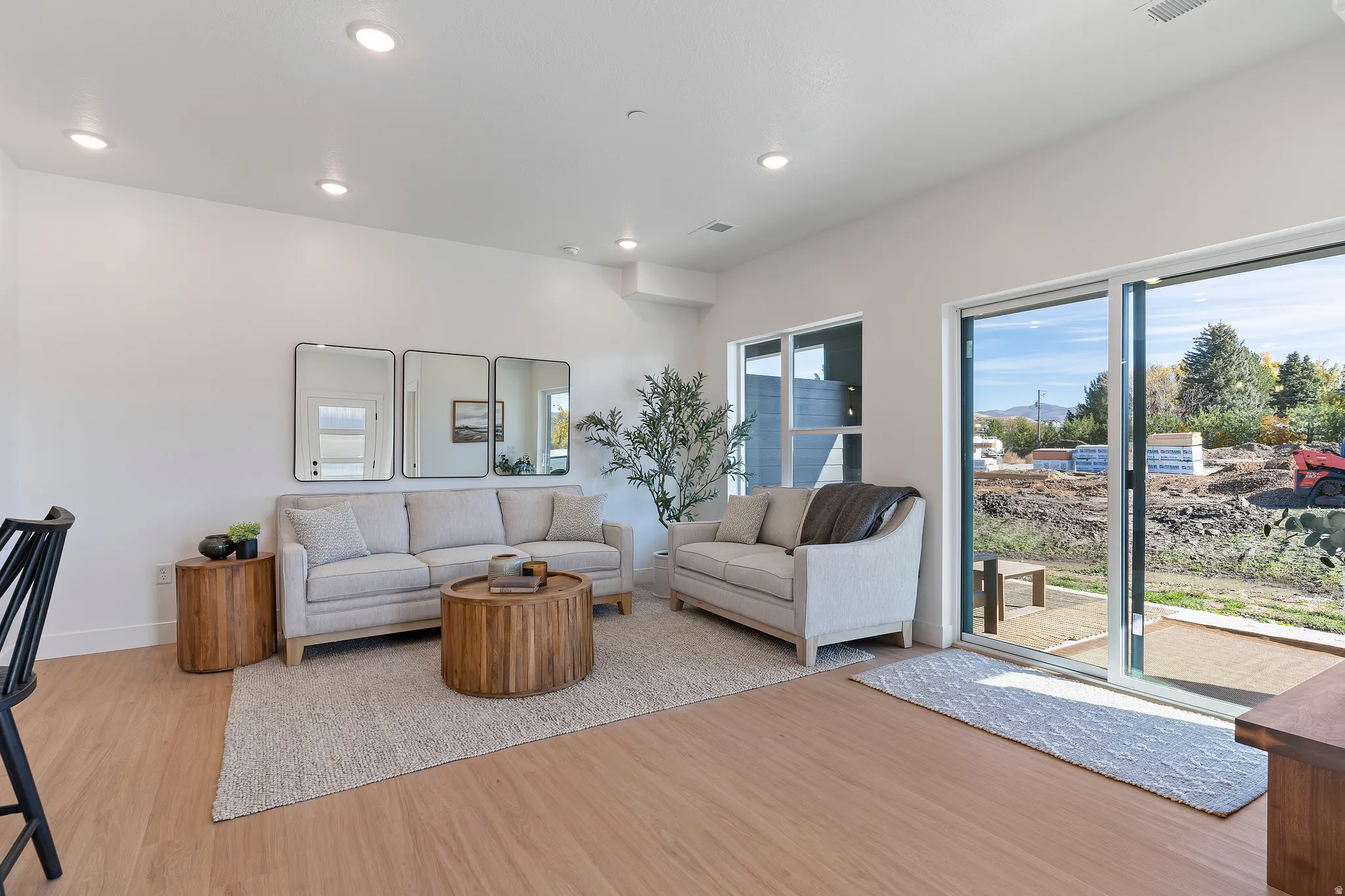 Recessed lighting, wood-finish flooring, white walls, and a sliding glass door