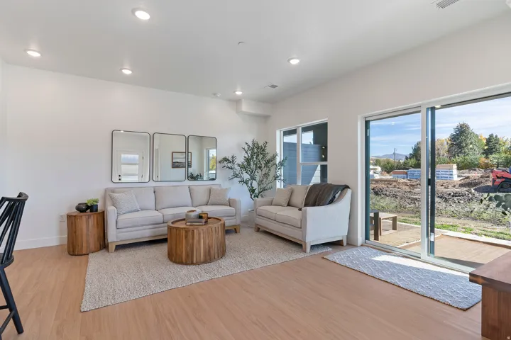 Recessed lighting, wood-finish flooring, white walls, and a sliding glass door