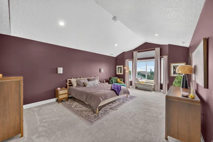 Vaulted ceiling, recessed lighting, and wall-mounted sconces illuminate this space