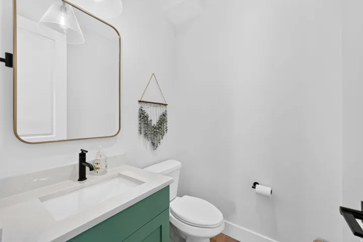 Modern vanity with a light-toned countertop, integrated rectangular sink, and matte black faucet