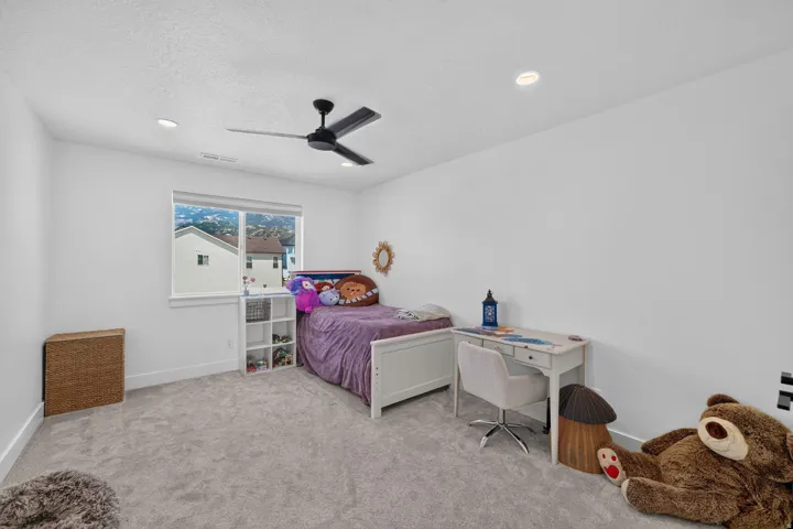 Recessed lighting, ceiling fan, carpeting, and a window with a white frame